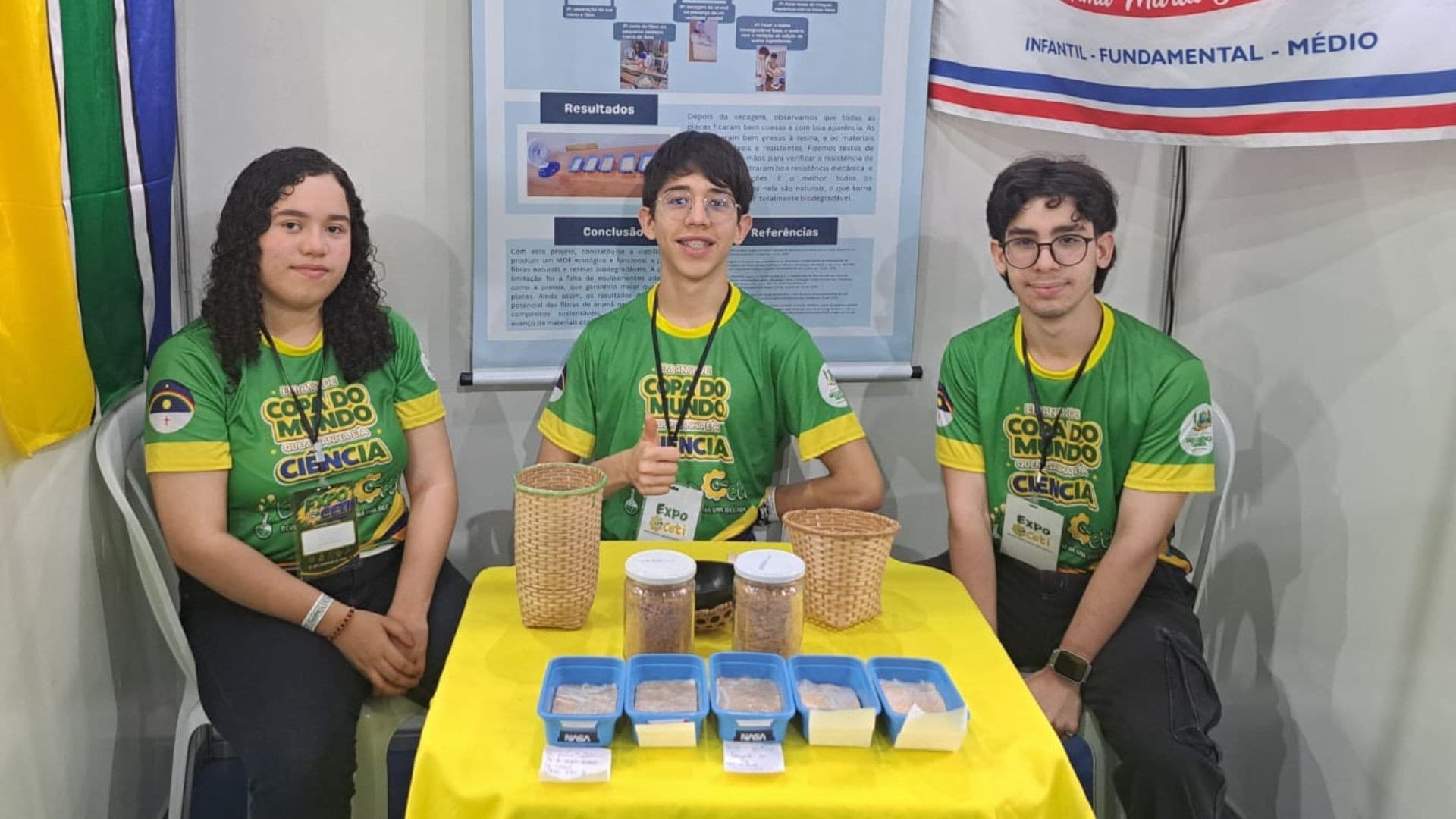Estudantes seguram protótipo de placa de MDF sustentável em laboratório.
