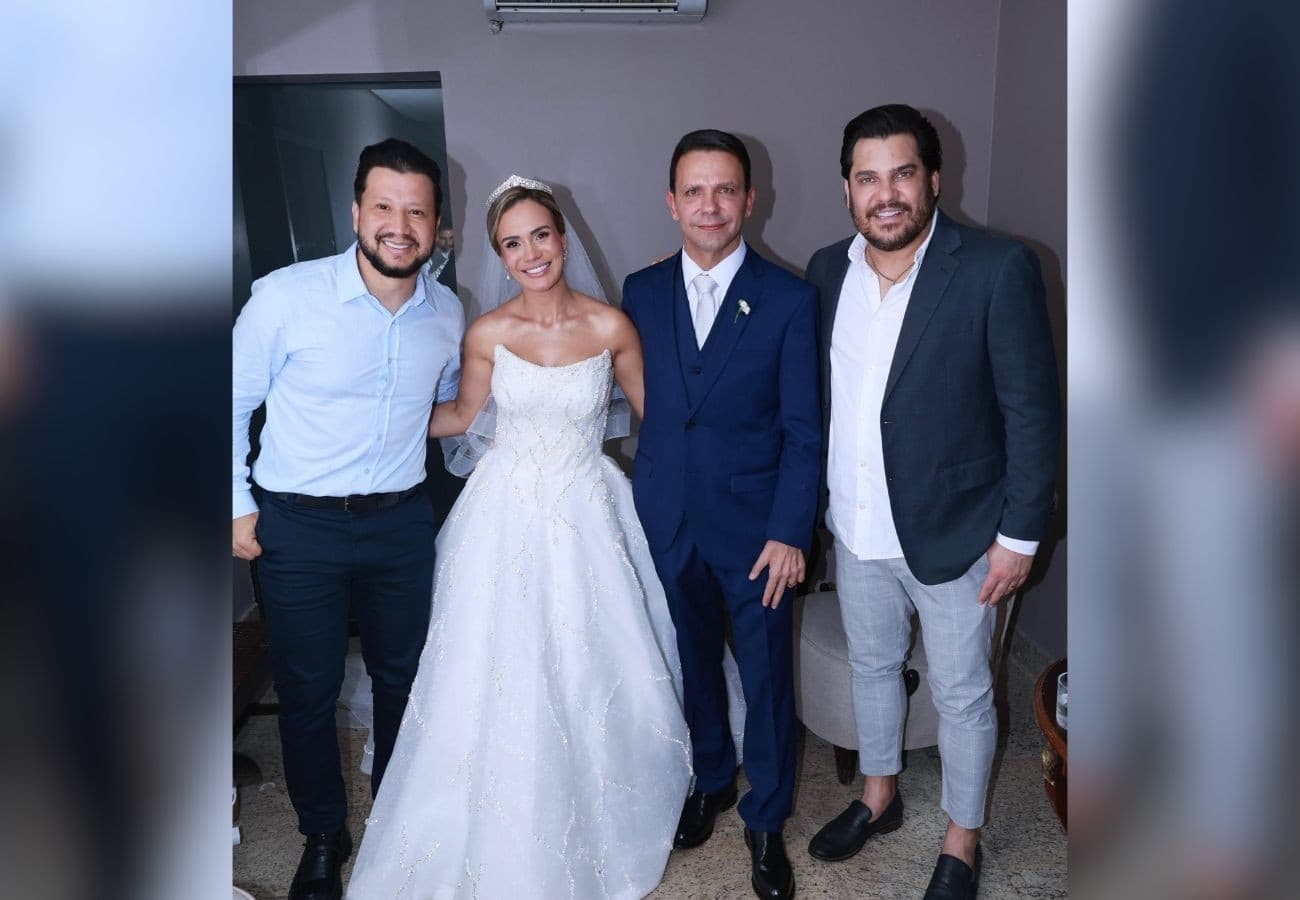 Membros da dupla sertaneja seguram microfones ao lado de mesa de casamento decorada em Palmas.