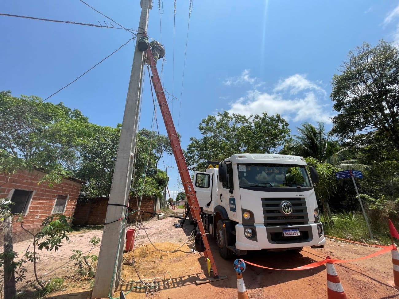 Trabalhador da CEA em poste em via pública em Macapá durante operação de manutenção.
