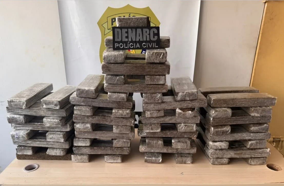 Tabletes de maconha apreendidos pela Polícia Civil sobre mesa em delegacia.