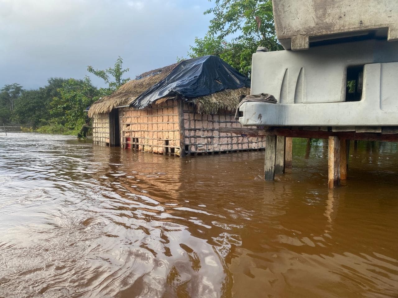 Helicóptero sobrevoa área alagada em Roraima durante transporte de equipamentos.