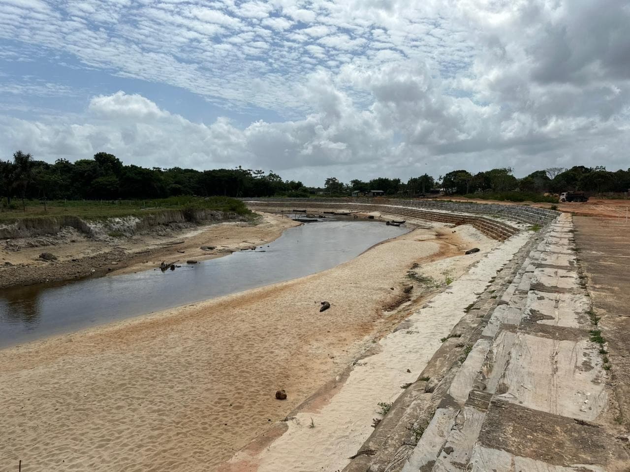 Margem de rio com terra exposta e rachaduras devido ao baixo nível da água durante estiagem no Amapá.