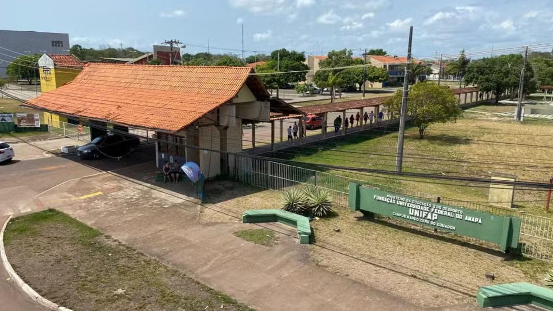 Computador exibindo página de inscrição da Unifap em mesa de escritório com livros ao lado.