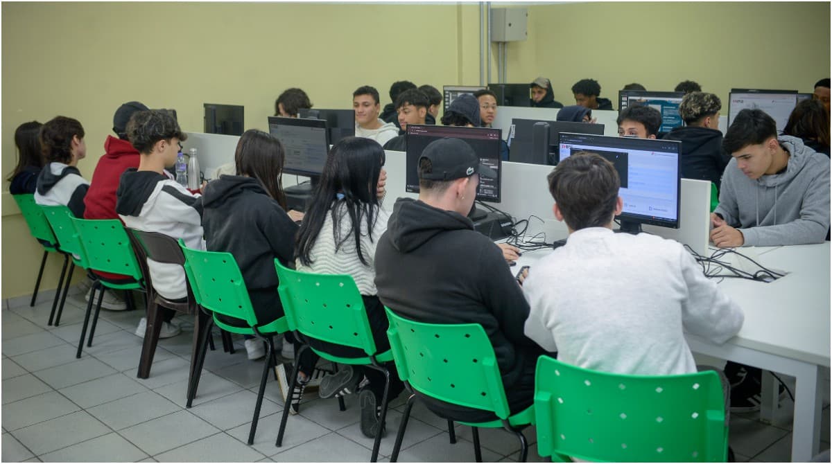Estudantes organizam documentos em mesa de escritório durante processo seletivo.