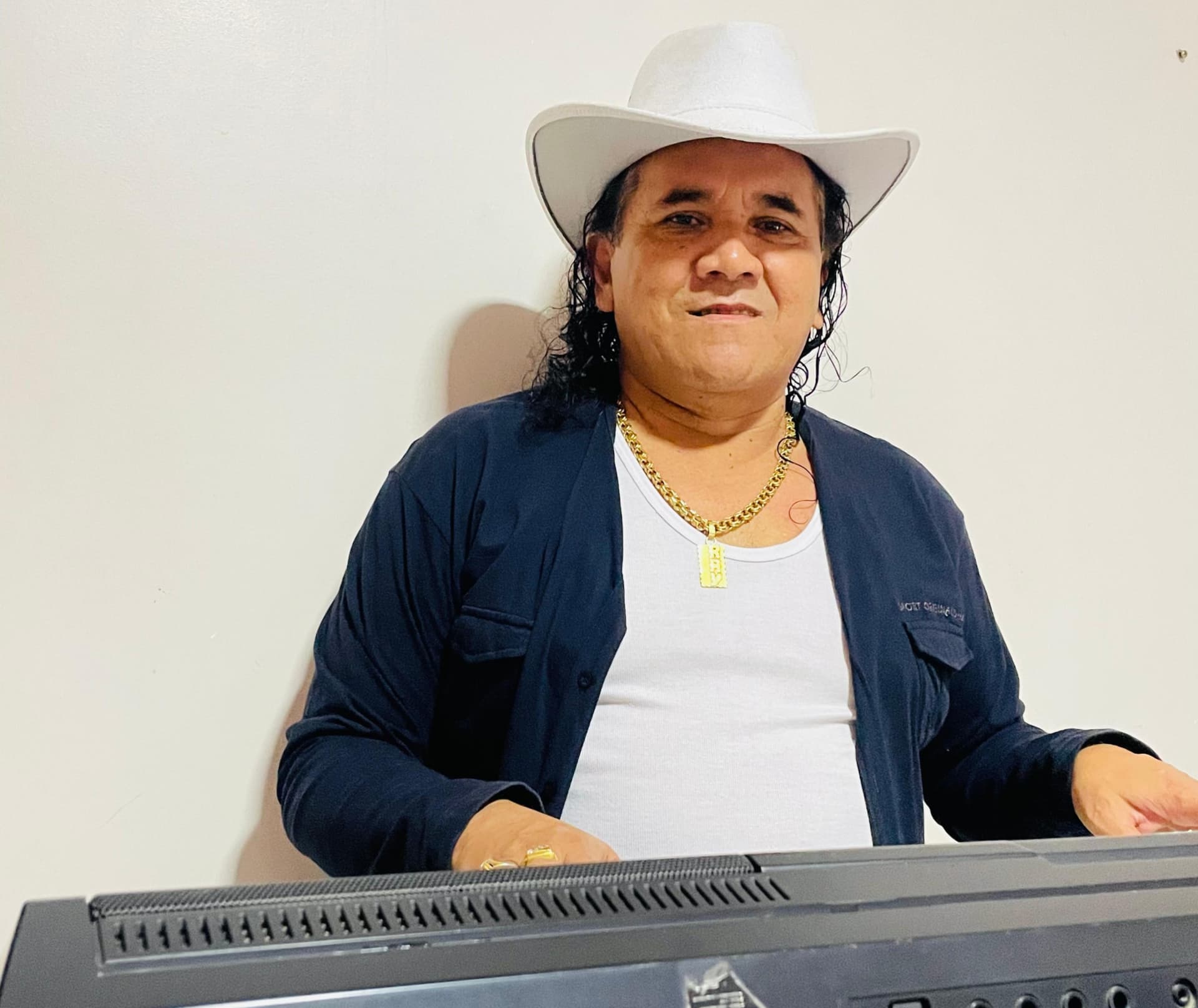 Teclado iluminado sobre palco escuro durante apresentação de forró.