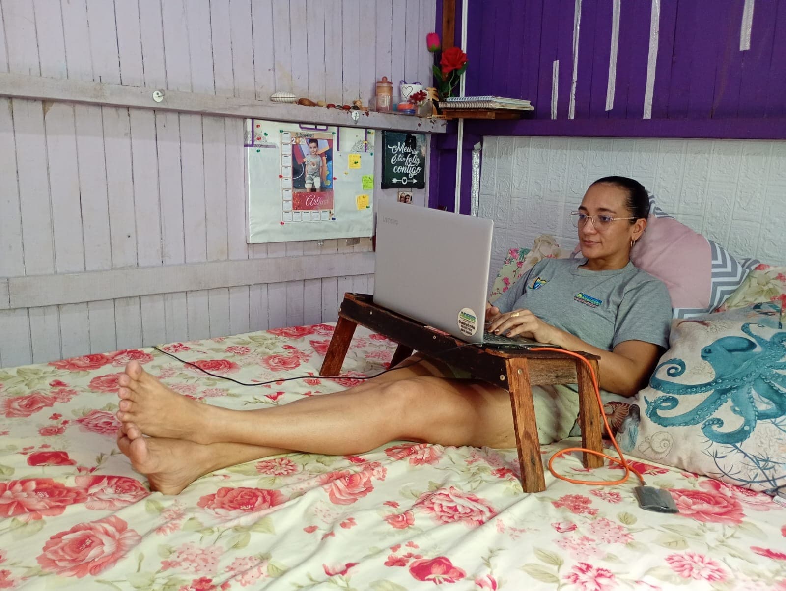 Mulher sentada em mesa de escritório com expressão de cansaço.