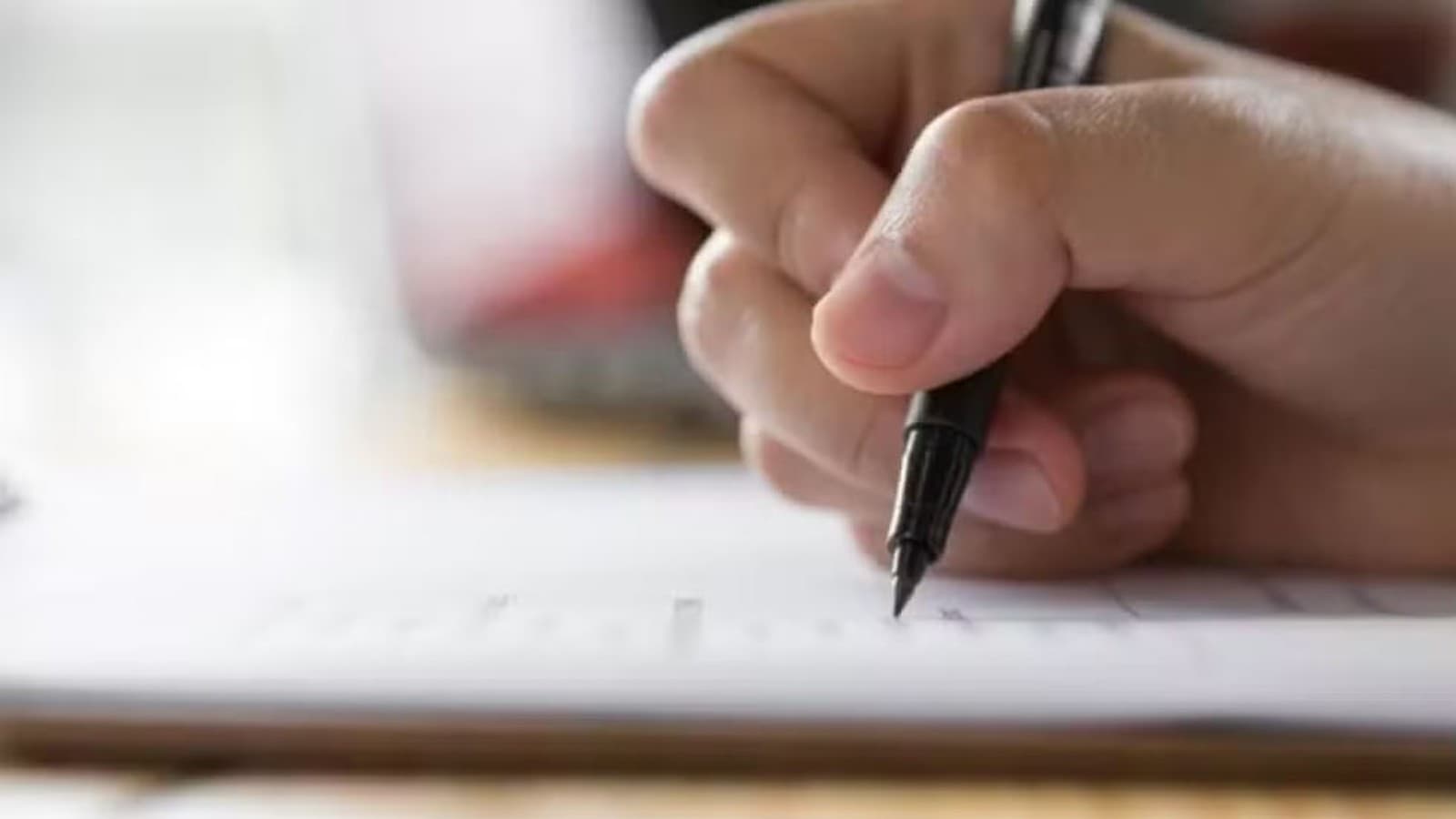Mãos digitam em um teclado de computador com tela exibindo o site de uma prefeitura.