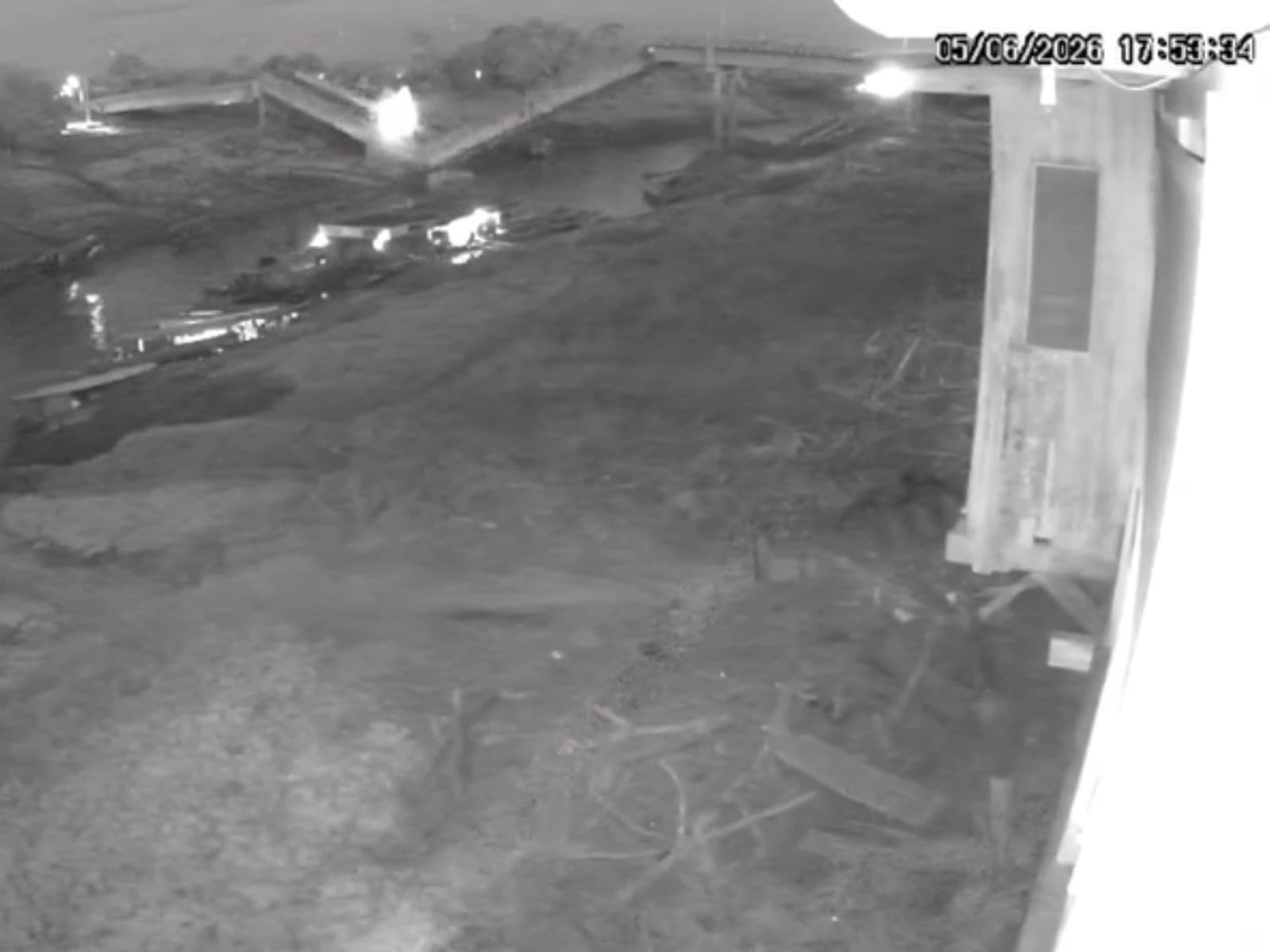 Restos de ponte de madeira caídos sobre leito de rio no Acre.