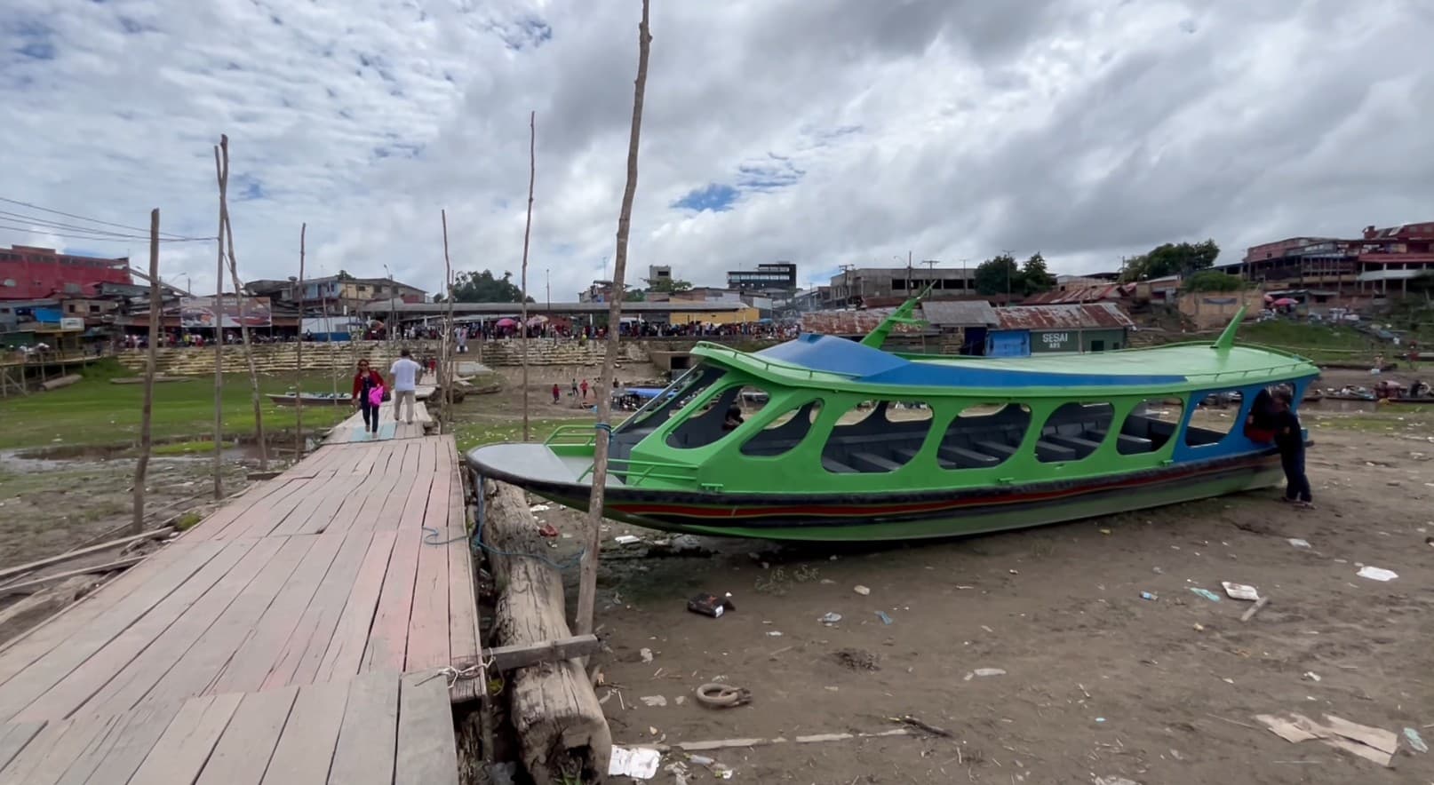 Margem do Rio Negro em Manaus mostra nível baixo da água expondo troncos e solo.
