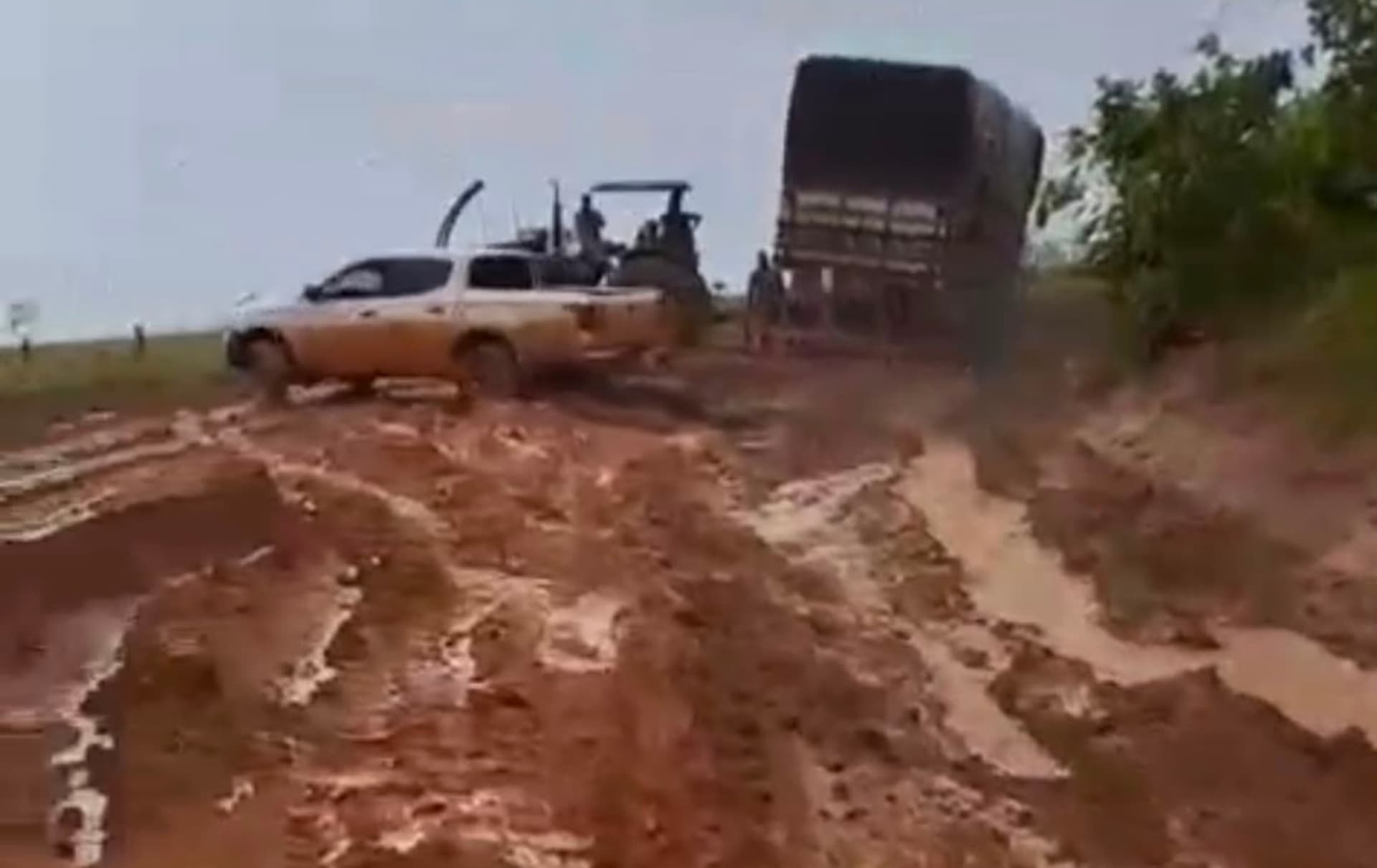 Estrada vicinal alagada com lama nas margens e carro parado em São Luiz do Anauá.